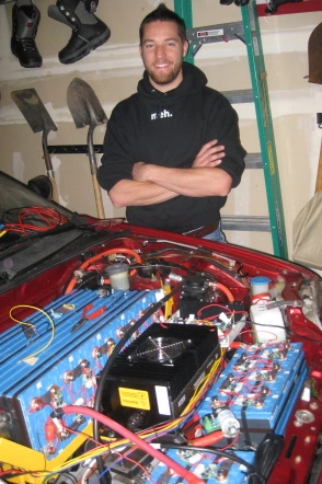 A man proudly displaying his EV drivetrain. EV grin prominent.