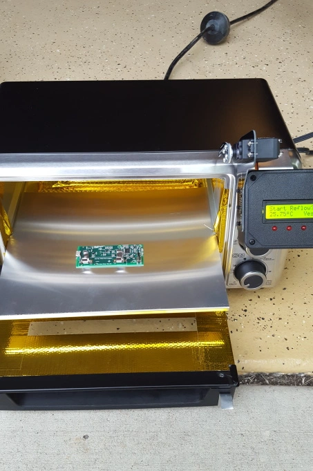 A PCB being baked in a reflow toaster oven